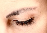 a close up of a woman's eye with long lashes