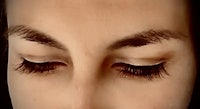 a close up of a woman's eyes with long lashes